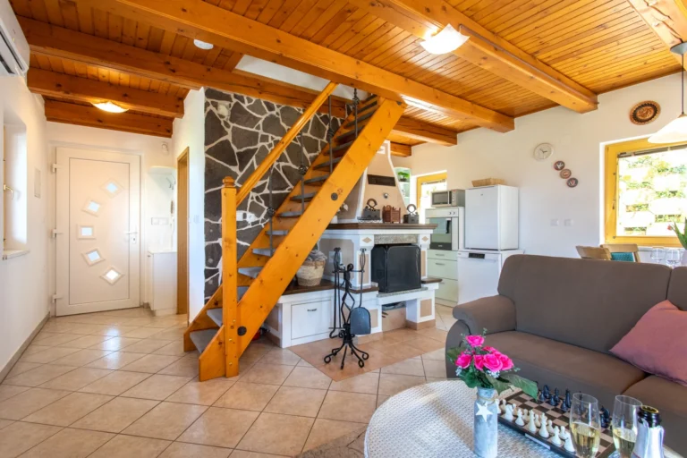 Living room with staircase and fireplace at Butterfly Place